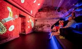 Menschen sitzen auf bank in einem gewölbekellerkino