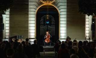  Raphael Heggendorn am Cello spielen unter Torbogen Innenhof  