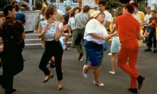 Szene aus dem Film Hairspray mit wild tanzendem Menschen auf der Strasse.