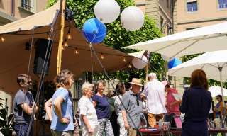 Im Innenhof des Berner Generationenhaus lauschen Menschen einer Rede zum «Tag für zukünftige Generationen».