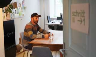Blick durch die Türe ins Büro von Schritt 1 im Berner Generationenhaus. Leiter Gérald Mathieu sitzt an einem Tisch.